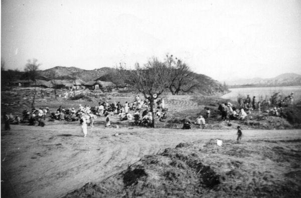 Civilians Wait to Cross a Bridge