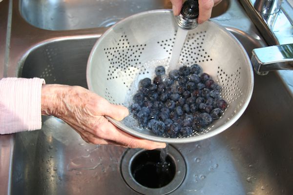 Step 2 - Wash BlueberriesUsing cold water and a colander Bernice washes the blueberries. She puts the washed berries in a 4 cup measuring dish. 